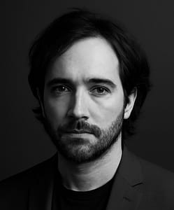 Black and white portrait of a bearded man.