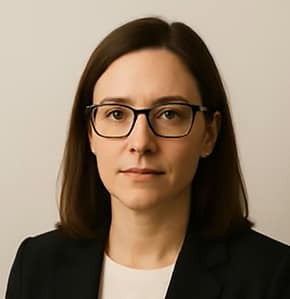 Person with glasses and dark hair in suit.
